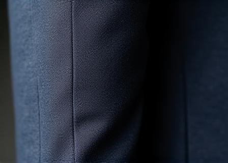 Détail de la texture textile et de la coupe asymétrique du blazer